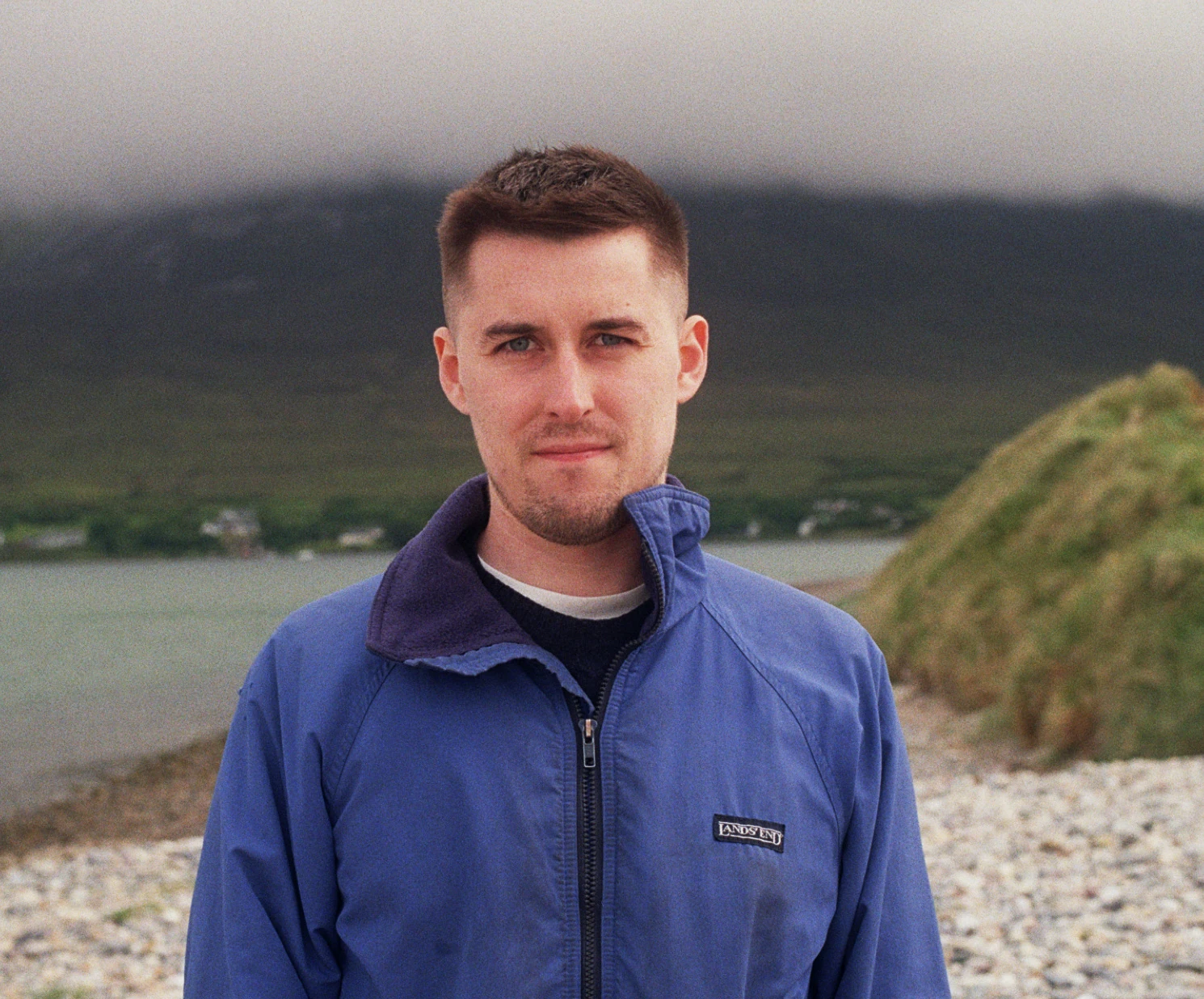image of Ciaran sitting standing on a beach